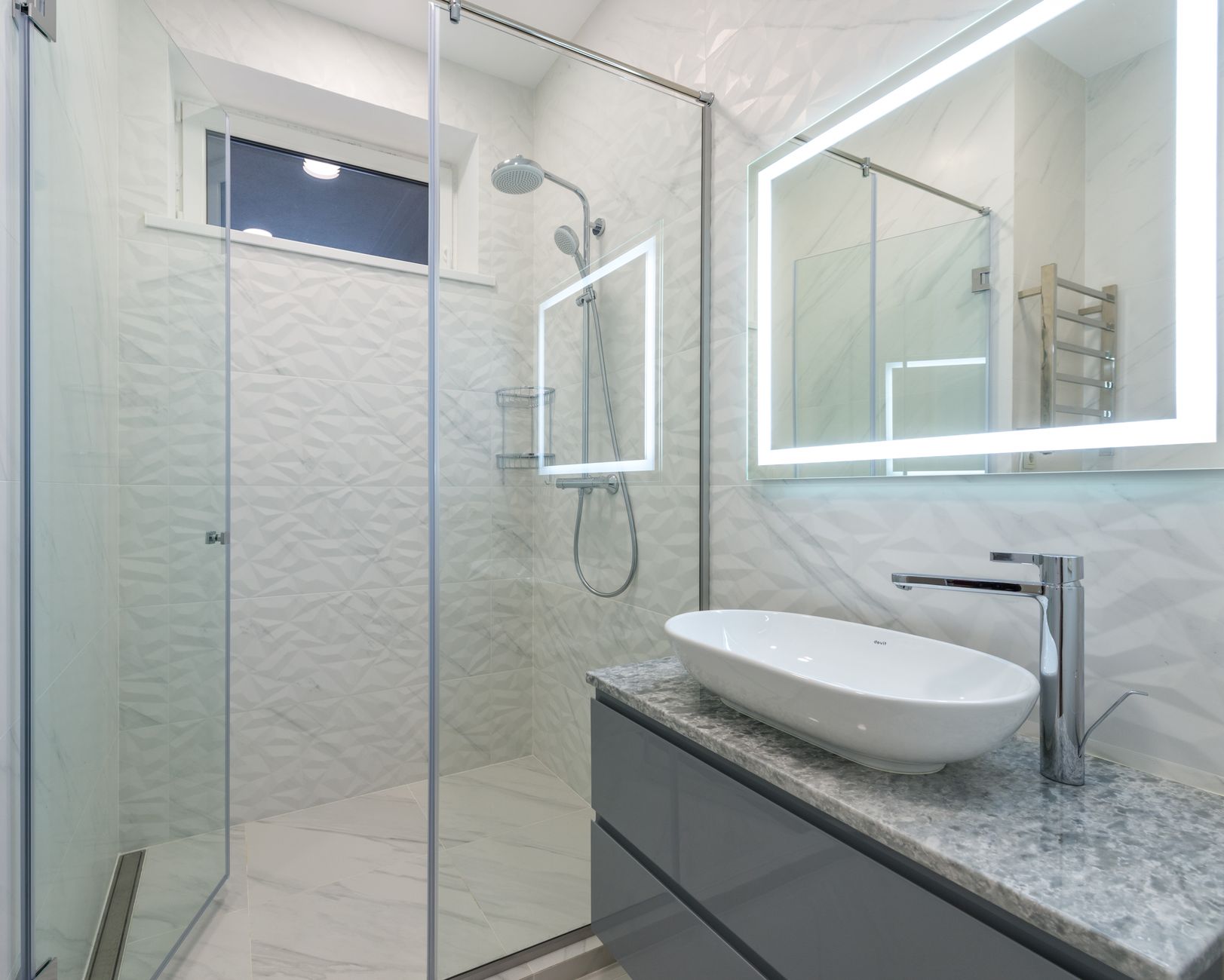 Small walk-in shower with glass enclosure in a compact bathroom